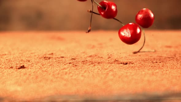 Super Slow Motion Fresh Cherry Falls on the Table with Cocoa alt