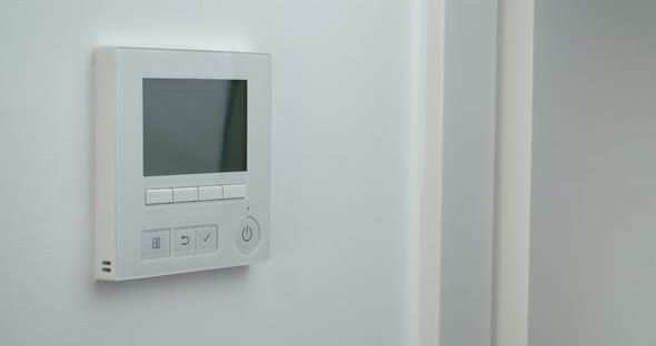 Woman Hand Changing Temperature in Remote Controller of Air Conditioner to Cold alt