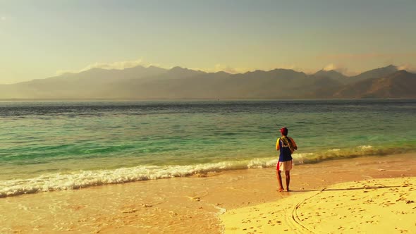 One boy fishing alone on relaxing bay beach voyage by blue green water with white sandy background o alt