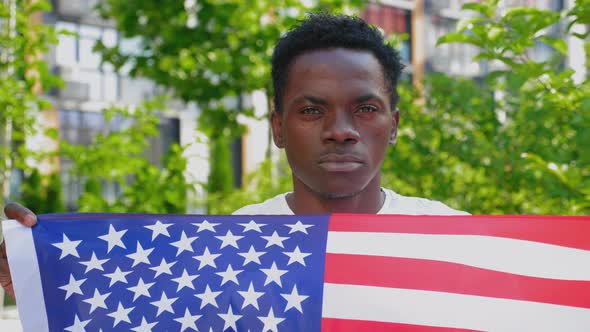 Close Up Smiling Afroamerican Man Holding American Flag Looks Camera in Summer alt