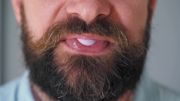 Bearded Man Chewing Bubble Gum. Man Blowing Out a Bubble of Chewing Gum alt
