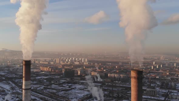 Aerial view of smoke rising from the chimney of a coal boiler. Dolly zoom effect. alt