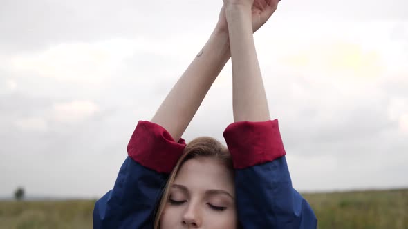 Young Woman Raises Her Hands Up