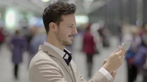 Lifestyle Portrait of Attractive Young Male Entrepreneur Browsing the Web Tablet Screen alt