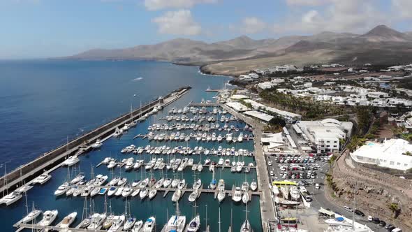 Aerial footage of the beautiful Boats and Boat Harbour Marina and pier taken in Lanzarote in Spain