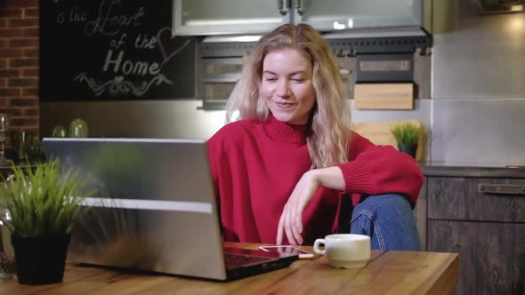 Freelance businesswoman sits desk typing on laptop and drinking morning coffee alt