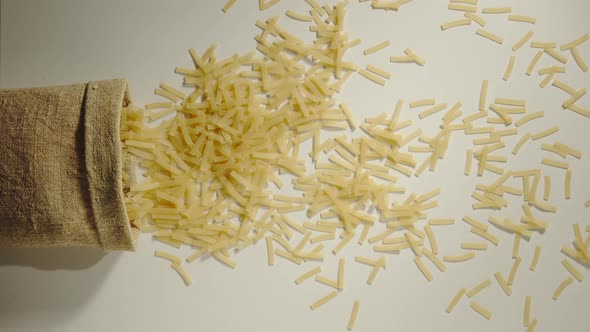 Bag Falls And Noodles Are Poured Out Of It On White Background