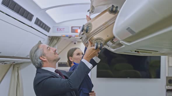 Flight attendant welcome passenger on board, advise seat and bring luggage to store in overhead bin. alt