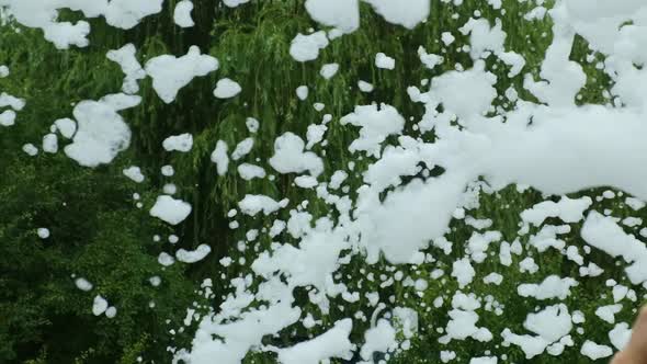 Foam disco in nature. Foam flies on the background of green trees. Slow motion 120 fps