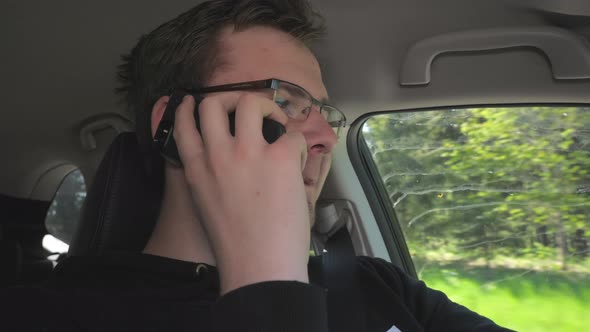 A Look of the Young Man Talking to His Phone While Driving