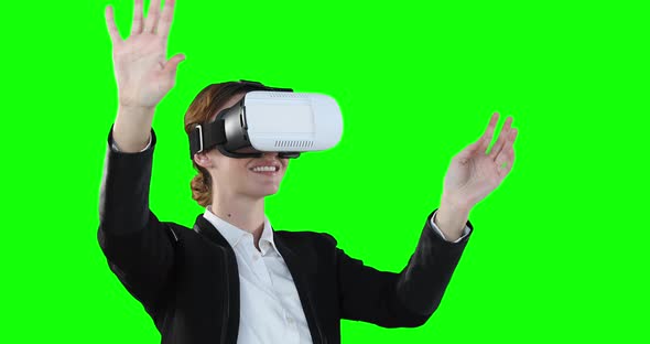 Caucasian woman wearing a VR headset on green background