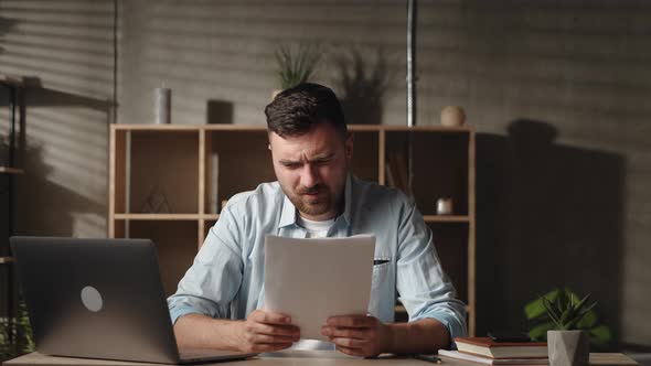 Frustrated Young Man Looking Through Paper Document Feeling Confused of Getting Bank Loan Mortgage alt