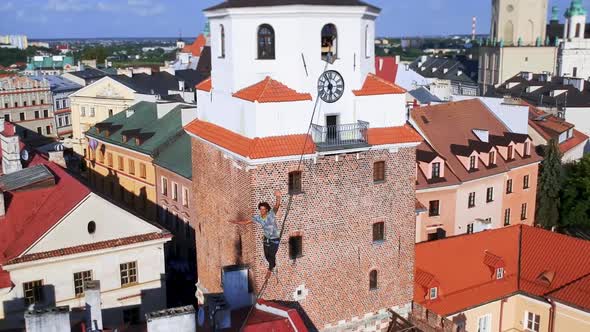 Man Balances on Tight Rope a View of the City From Height alt