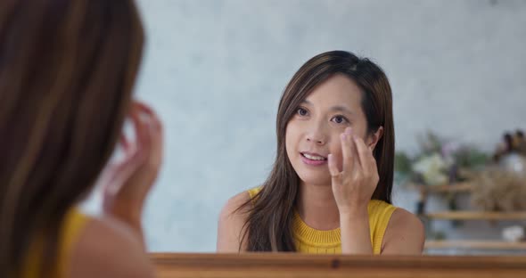 Woman use finger touch on her face in beauty make up studio  alt