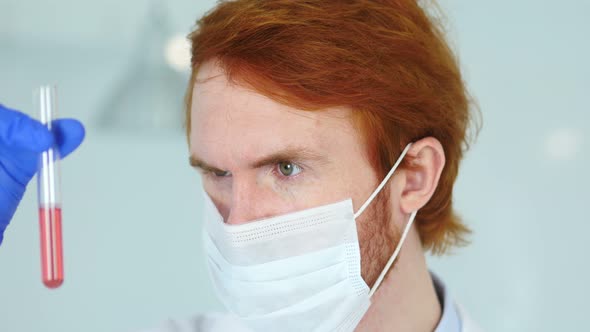 Scientist Studying red Solution in Test Tube in Laboratory alt