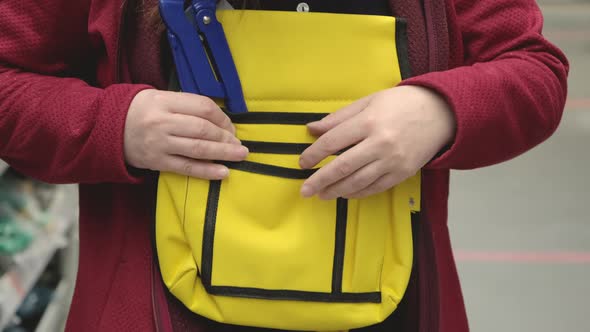 Woman in Store Chooses Sturdy Yellow Tool Bag
