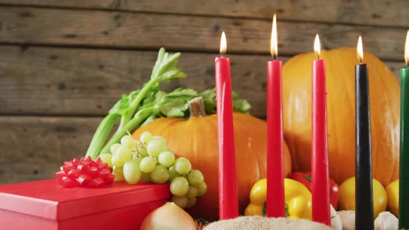 Composition of seven lit candles and halloween pumpkins, present and vegatables alt