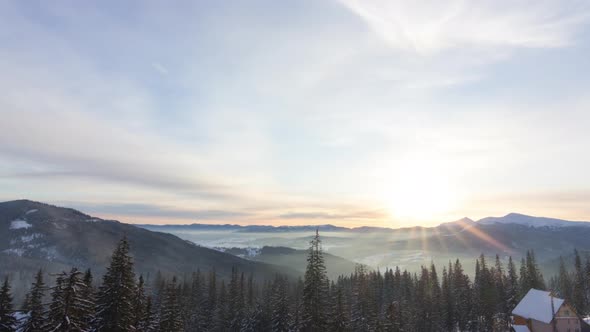Aerial View of Sunrise in Winter Forest Mountains with Lot of Snow and Snowy Trees in Cold Morning