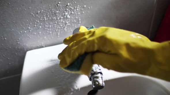 Girl Washes a Silver Faucet in a Bidet in Rubber Yellow Gloves alt