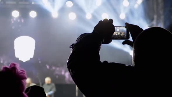 Male Record Video on a Smartphone of a Night Rock Concert on Open Stage alt