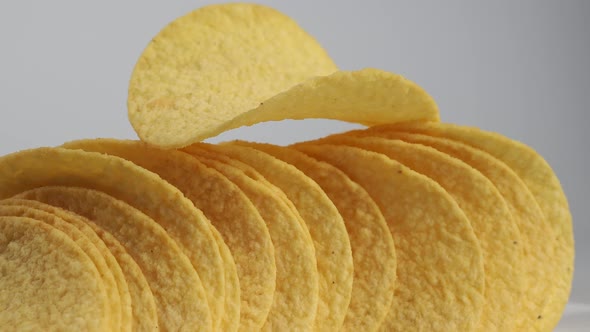 Fried potato chips rotating on a white background. Crispy chips. alt