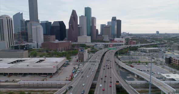 Aerial view of traffic on freeway near downtown Houston on a cloudy day during sunset. This video wa alt