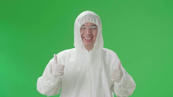 Asian Male Wearing Uniform Ppe And Showing Thumbs Up In Green Screen Studio alt