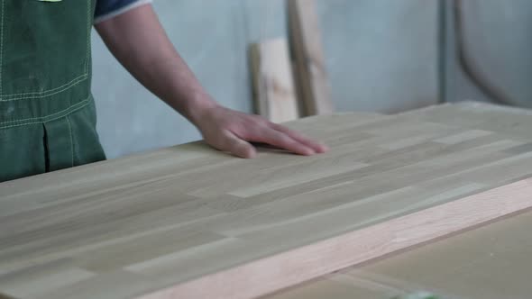 Man Polishing Wooden Surface Works As a Grinder alt