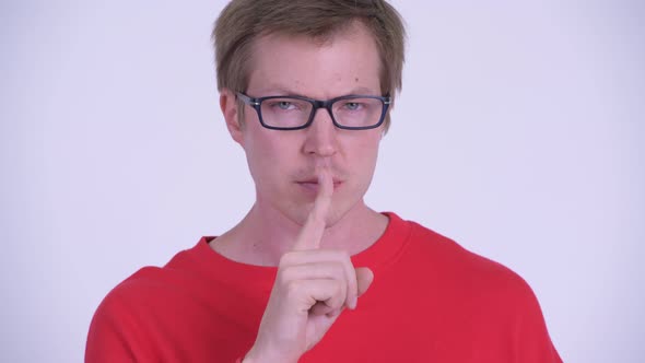 Face of Serious Young Man with Finger on Lips alt