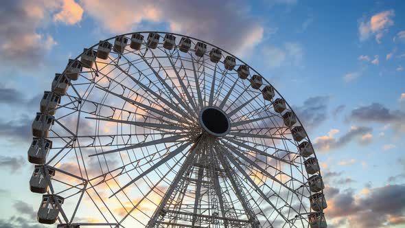 Ferris wheel silhouette at sunset - time lapse - against beautiful clouds in the sky alt