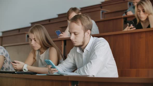 Multi Ethnic Group of Students Using Smartphones During the Lecture alt