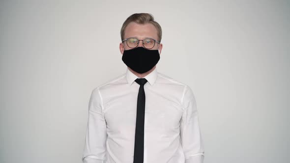 Portrait of Male Office Worker Wearing White Shirt and Mask. Standing on Wall Background. Protecting