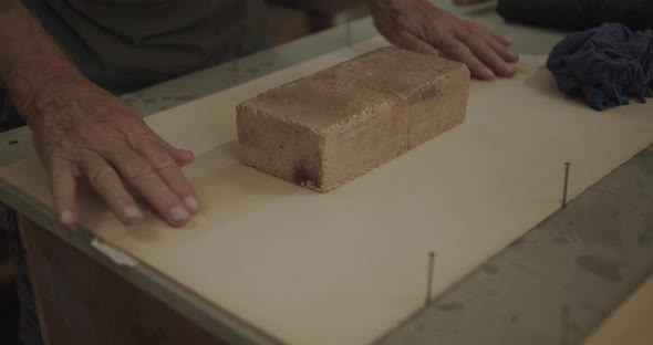 stone block holding down glued wood planks