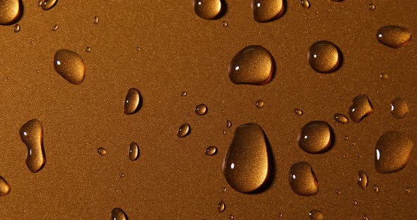 Abstract water drops on gold bronze background, macro alt