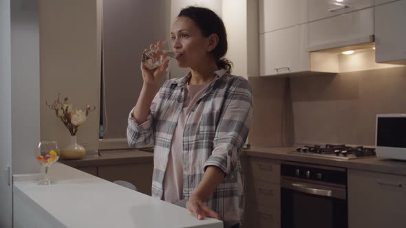 Adult Woman Drinking Glass of Water Enjoying Freshness Smiling Indoors alt