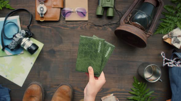 Top View of Female Hands Putting Passports on Table alt