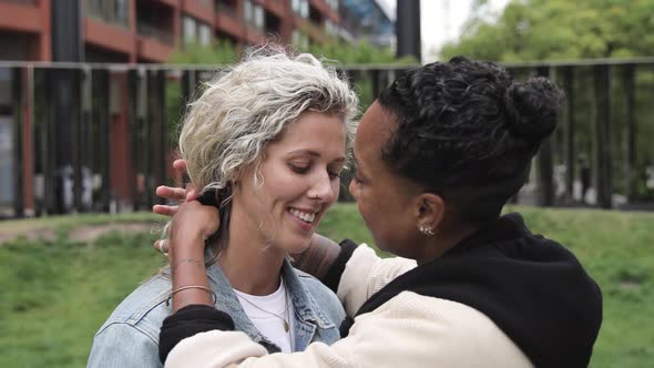 Happy mixed race lesbian couple in love kissing and cuddling - Girlfriends, m alt