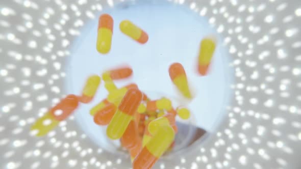 Orange Capsules Of The Medication Is Falling Down Into The Camera