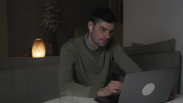 Man is using laptop computer at night