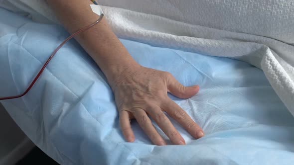 Hand of Sick Senior Patient Squeezing Bed Sheet in Hospital, Suffering Pain