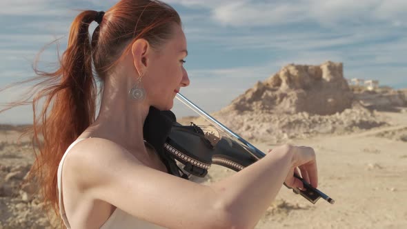 Red-haired woman is playing the violin