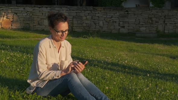 In the morning with a gadget on the grass. alt