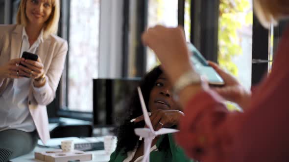 Young woman speaking during meeting with wind wheels at office alt