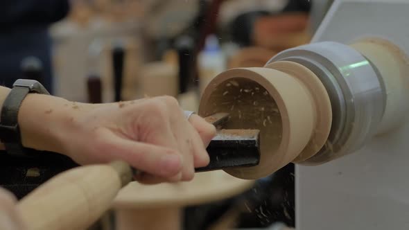 Slow Motion Carpenter Using Chisel for Shaping Piece of Wood on Lathe Close Up