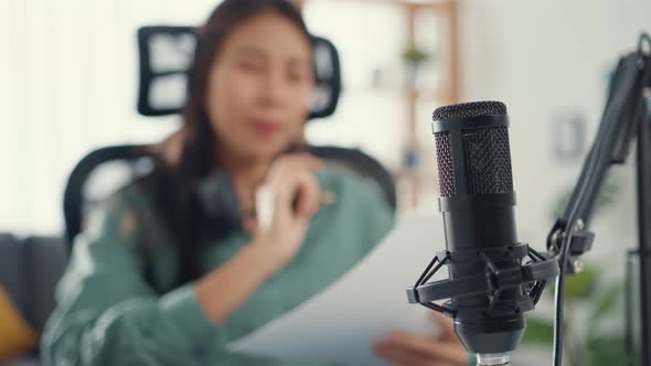 Attractive asia girl record podcast use microphone hold paper creating content for audio blog talk.
