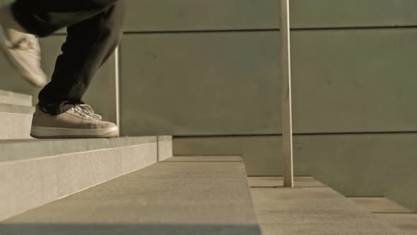 Legs of a Young Man Jumping Down the Stairs of an Underpass or Subway