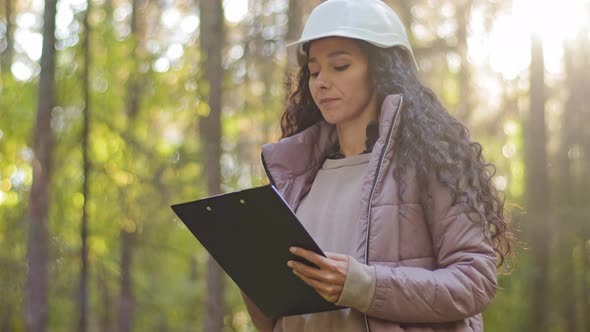 Millennial Female Technician Ecologist Looking Up at Treetops Young Indian Woman in Hardhat with alt