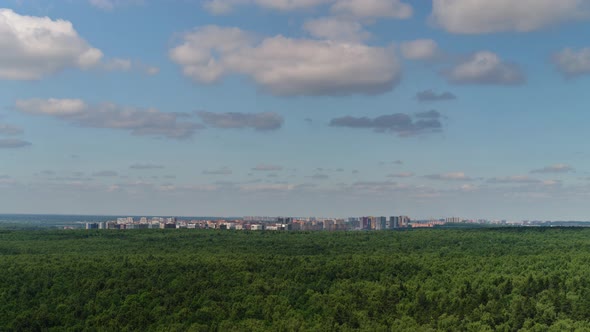 Clouds over the forest and the city alt