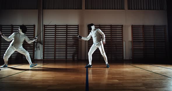 Fencers Thrusting And Parrying At Each Other With Their Foils alt