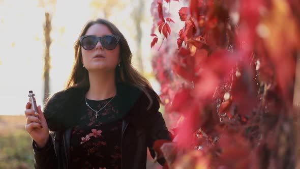 Young girl using ecig evaporation gadget to quit smoking nicotine cigarettes. alt